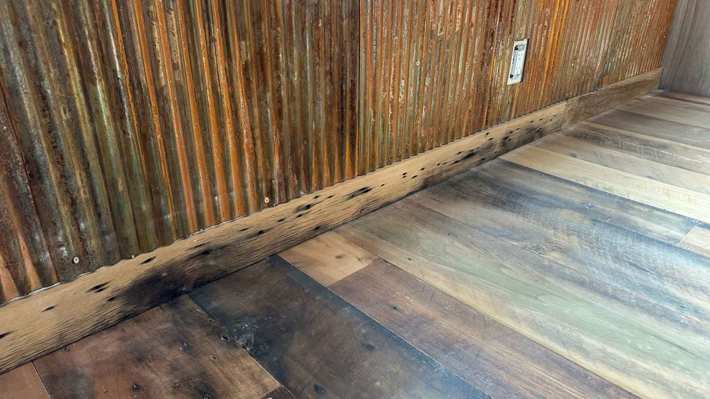 image of corrugated metal against the reclaimed barn wood floor